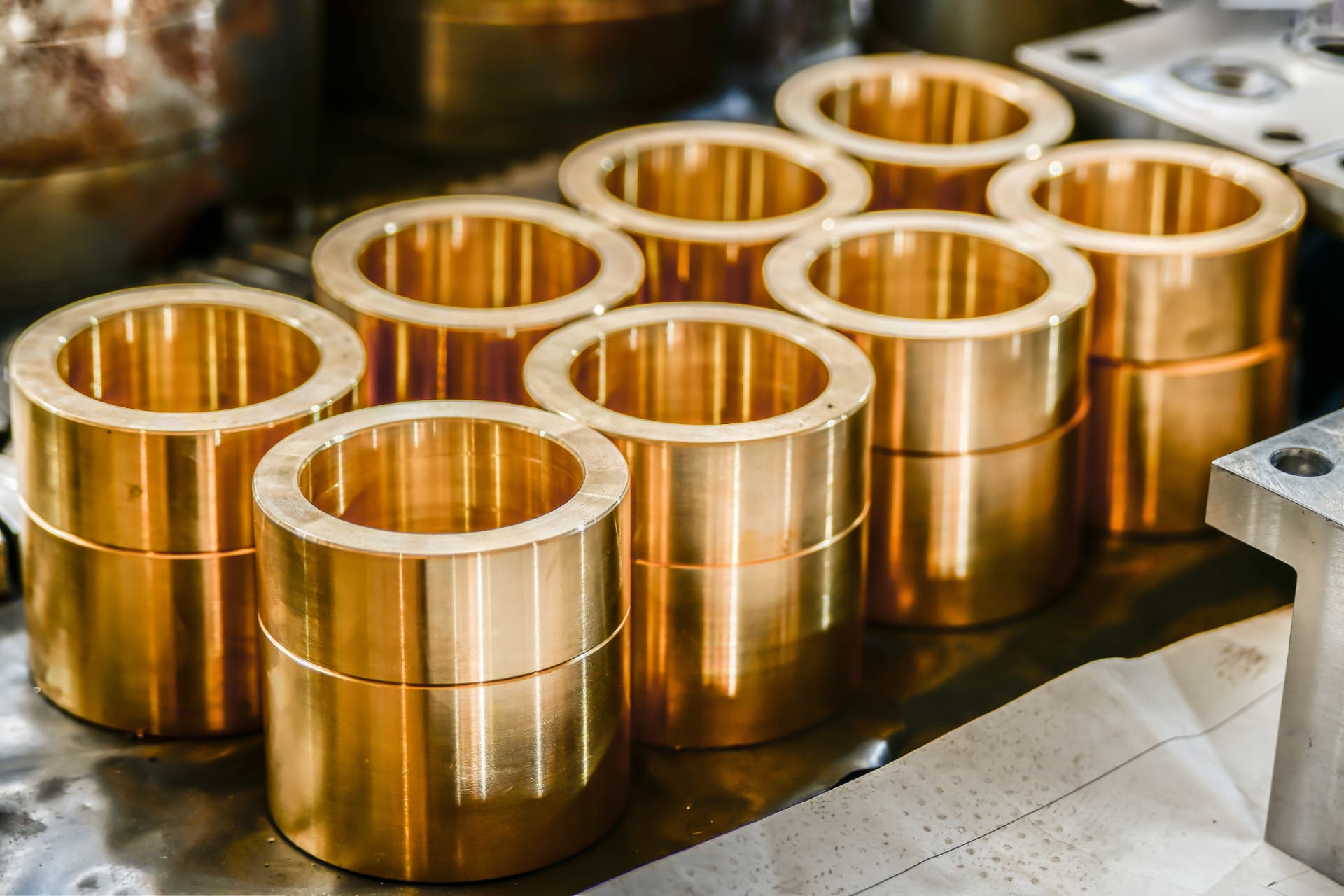 Precision-machined metal bushings on a workshop bench