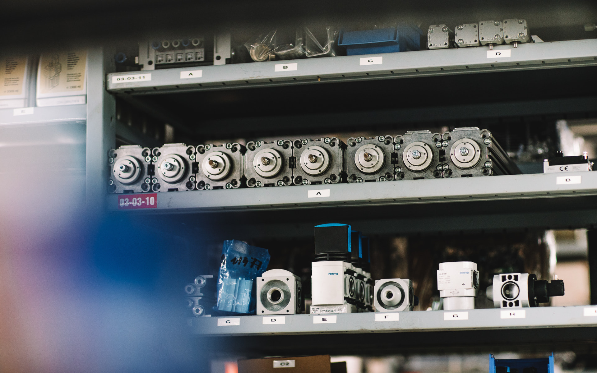 Mechanical and pneumatic components organized on industrial storage shelves